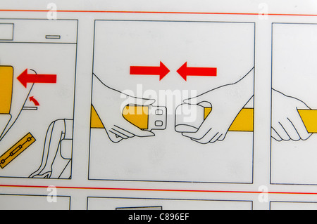 Nahaufnahme einer Airline-Sicherheit-Karte zeigt, wie man schließen und verriegeln Sie die Sicherheitsgurte Stockfoto