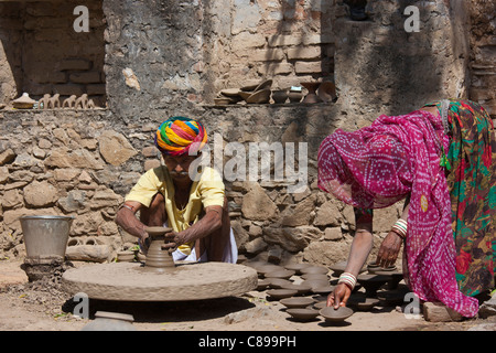 Indische Potter in Rajasthani Turban arbeitet zu Hause mit seiner Frau machen Tontöpfe in Dorf Nimaj, Rajasthan, Indien Stockfoto