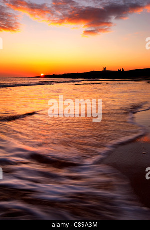 Sonnenaufgang über dem Dunstanburgh Castle, Embleton Bay, Northumberland, England, Vereinigtes Königreich. Stockfoto