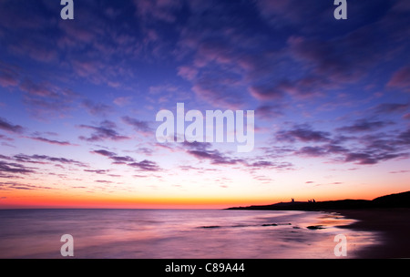 Sonnenaufgang über dem Dunstanburgh Castle, Embleton Bay, Northumberland, England, Vereinigtes Königreich. Stockfoto