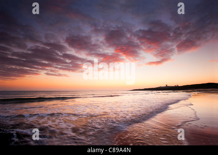 Sonnenaufgang über dem Dunstanburgh Castle, Embleton Bay, Northumberland, England, Vereinigtes Königreich. Stockfoto