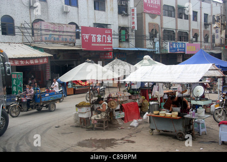 Ein Tour-Bus navigiert durch die Straßenhändler in Jingzhou, China Stockfoto