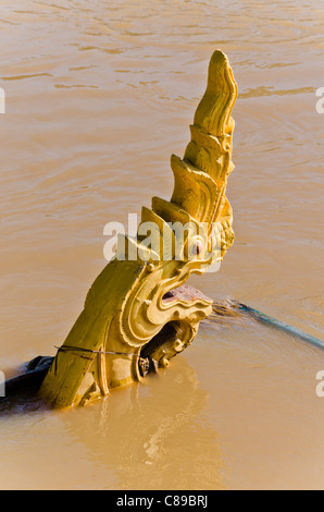 Dragon (Naga) Skulptur im Sonnenschein, die teilweise unter Wasser durch die schlammigen Hochwasser des Flusses Ping in der Nähe von Chiang Mai Thailand Stockfoto
