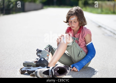 Deutschland, Bayern, Wounded Mädchen sitzen auf der Straße nach Inline-Skater Unfall Stockfoto