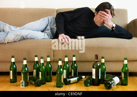 Deutschland, Hessen, Frankfurt, betrunkenen Mann auf Sofa liegend mit leeren Bierflaschen Stockfoto