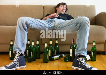 Deutschland, Hessen, Frankfurt, betrunkenen Mann auf Sofa liegend mit leeren Bierflaschen Stockfoto