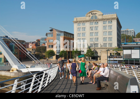 Menschen auf Gateshead Millennium Bridge. Malmaison Hotel in Newcastle Quayside im Hintergrund. England, UK Stockfoto