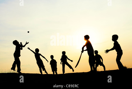 Silhouette des indischen jungen französischen Fussball bei Sonnenuntergang in Indien Stockfoto