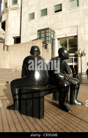 Statuen von Menschen sitzen auf Bank Canary Wharf Docklands London Stockfoto