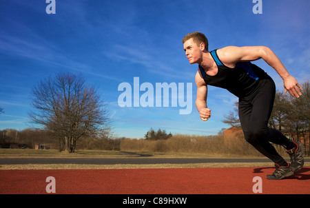 Mann in Sprint auf Sportstrack zu beschleunigen. Links Exemplar. Stockfoto