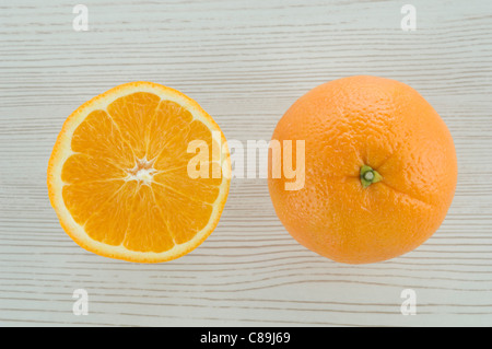 Orange ganz und in Scheiben schneiden, auf hölzernen Hintergrund Stockfoto