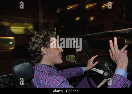 Deutschland, Hamburg, Mann klassischen Cabriolet Autofahren in der Nacht Stockfoto