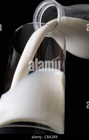 Milch in Glas gießen Stockfoto