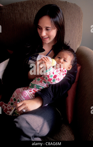 Ein fünf Monate altes Hispanic Baby trinkt aus der Flasche. Stockfoto