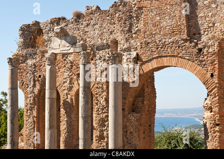 Spalten und Wand innerhalb des griechischen Theaters, und Blick auf den Golfo Di Naxos, Taormina, Sizilien, Italien Stockfoto