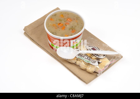 Eine nehmen Weg Tasse Kartoffel-Lauch Suppe mit einem Löffel & Oyster Cracker auf weißem Hintergrund, ausgeschnitten. Stockfoto