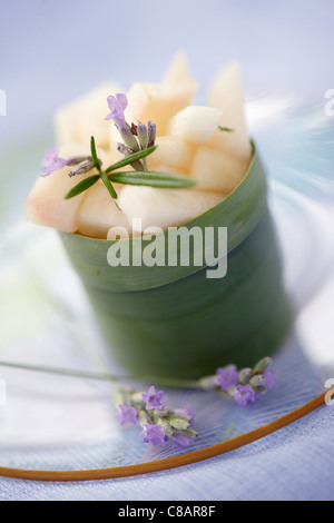 Weißer Pfirsich-Salat mit Rosmarin in einem Bananenblatt serviert Stockfoto