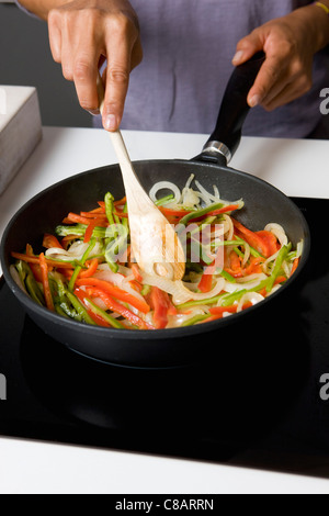 Die Paprika und die Zwiebeln in einer Pfanne Kochen Stockfoto