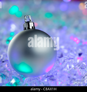 Silber von Weihnachtskugel auf bunt leuchtende Eiswürfel Stockfoto