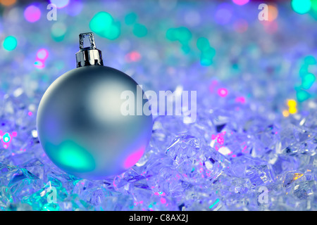 Silber von Weihnachtskugel auf bunt leuchtende Eiswürfel Stockfoto