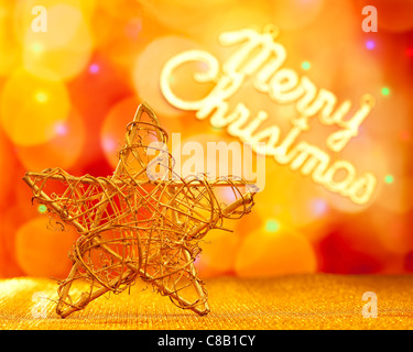 Goldener Stern mit Frohe Weihnachten in Lichter Hintergrund geschrieben Stockfoto
