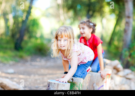 Kind Mädchen spielen auf Trunks Knie lange Spaziergänge in Wald Natur Stockfoto