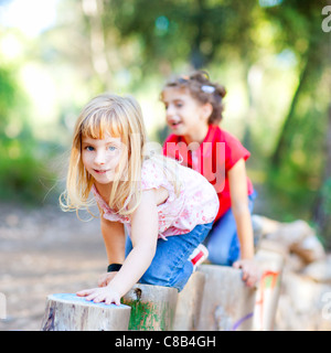Kind Mädchen spielen auf Trunks Knie lange Spaziergänge in Wald Natur Stockfoto