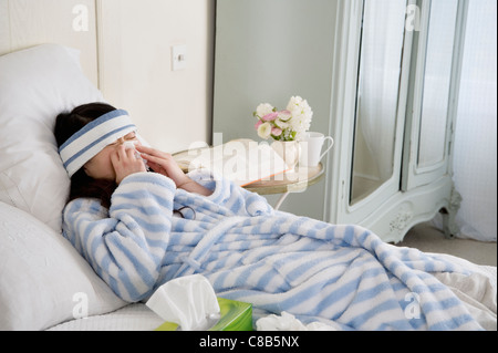 Junge Frau krank im Bett Stockfoto