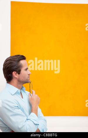 Nahaufnahme von einem nachdenklichen jungen Mann vor Wandmalerei Stockfoto