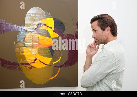 Nachdenklicher Mann betrachten Wandmalerei in Kunstgalerie Stockfoto