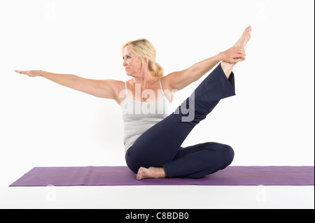 Mittlere gealterte Frau Yoga auf weißem Hintergrund zu tun Stockfoto