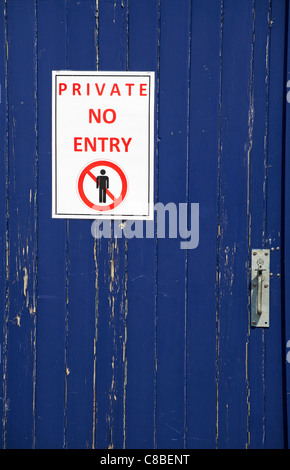 In Großbritannien gab es in Großbritannien ein Schild mit einem Schild, auf dem die blau gestrichene Tür abblätterte Stockfoto