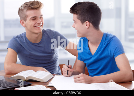 Zwei junge Burschen, die zusammenarbeiten, um die Bibel zu studieren Stockfoto