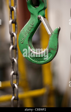 Ein Haken am Ende einer Kette an einem Flaschenzug befestigt. Stockfoto