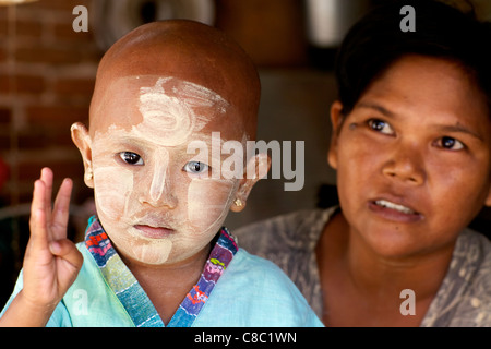 Nicht identifizierte Mutter und Tochter tragen traditionelle Thanaka-Creme in Nyaung-U, Myanmar Stockfoto