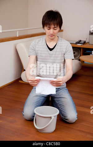 Junger Mann hält Staubtuch Stockfoto