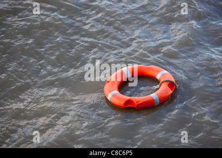 Orange Life Saver ring schwimmend auf der Themse, London, England, UK. Stockfoto