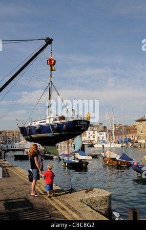 Segelboot aus dem Wasser für die Reinigung von Weymouth Harbour Dorset England UK aufgehoben Stockfoto