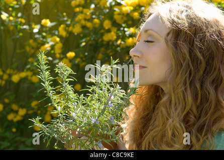 Frau, die duftenden Kräuter im Garten Stockfoto