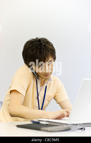 Junger Mann im ungezwungenen Gespräch auf Smartphone-Geschäft Stockfoto