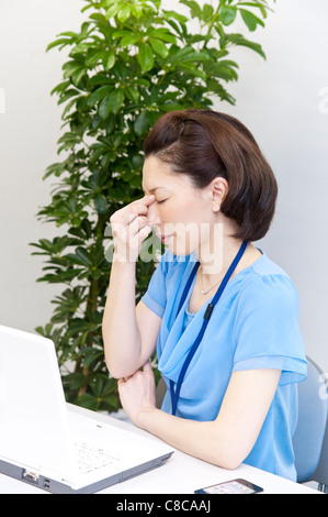 Mitte Erwachsene Frau, die unter Kopfschmerzen leiden Stockfoto