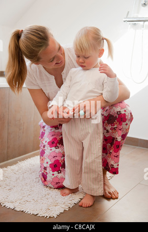 Mutter putzt ihre Tochter in Bad Stockfoto