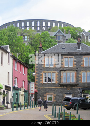 Oban, mit der Brennerei im Vordergrund und McCaig es Tower (oder Dummheit) dominieren den Hügel jenseits. Stockfoto