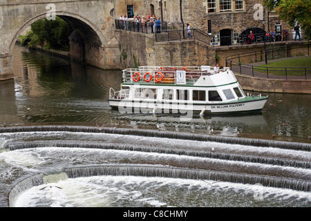 Genießen Sie eine Fahrt mit dem Sir William Pulteney Boot entlang des Flusses Avon, nachdem sie unter der Pulteney Brücke in Bath, Somerset UK im August passiert Stockfoto