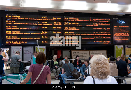 Passagiere, die Blick auf einen Passagier-Informationstafel am Bahnhof Kings Cross Station in London. Stockfoto