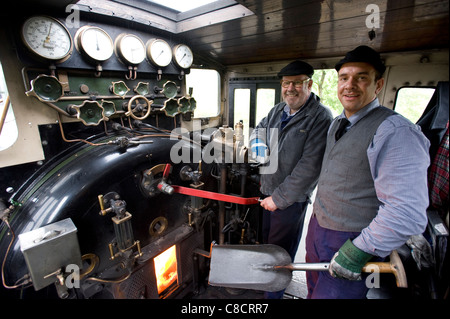 Schmalspur Dampf Lok ehrenamtliche Lokführer, eine im Ruhestand, eine jüngere, auf der Welsh Highland Railway. Stockfoto