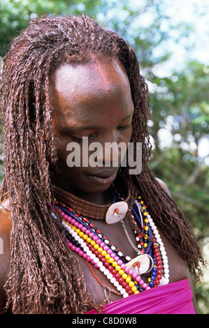 Lolgorian, Kenia. Siria Maasai Manyatta; Olelekule, Moran, roten Ocker gefärbt geflochtene Haare, Schale Dekoration. Stockfoto