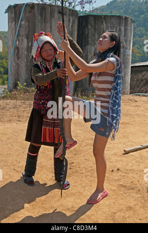 Akha Frau hilft ein Tourist auf der Dorf-Schaukel in der Nähe von Chiang Rai, Thailand Stockfoto