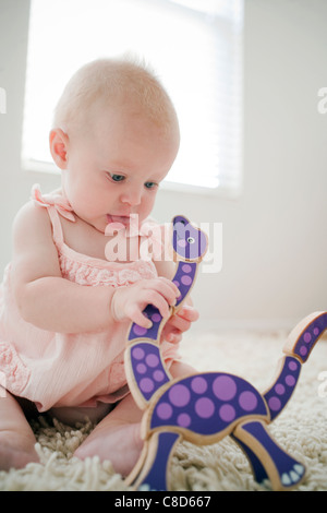 Babymädchen spielen mit Holzspielzeug Stockfoto