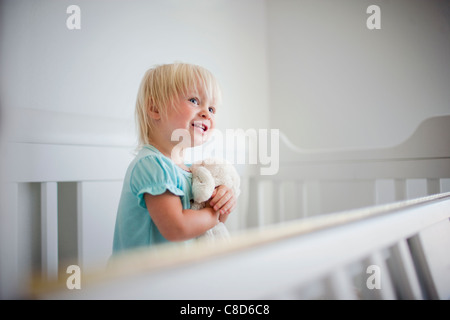 Kleinkind Mädchen In Krippe Holding Plüschtier, Nahaufnahme Stockfoto